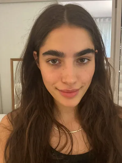 Selfie: long dark hair, strong brows, shadows under the eyes.