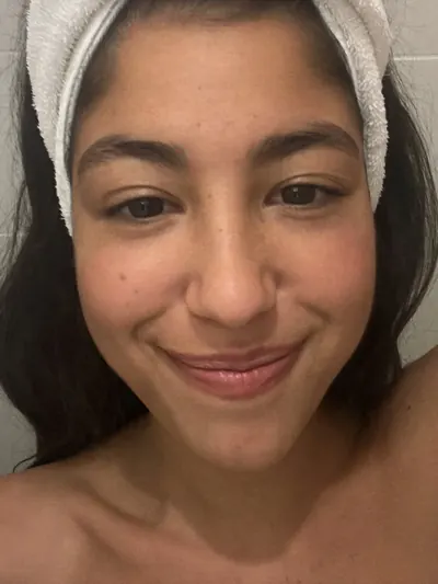 Selfie after washing up: towel headband, dark marks on her cheeks.
